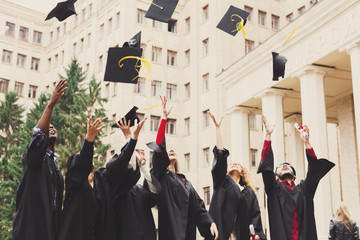 A group of graduates throwing graduation caps in the air