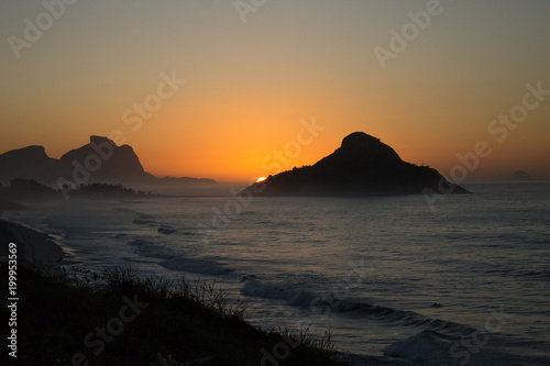color photography of sunrise between mountain on macumba beach in rio de janeiro city