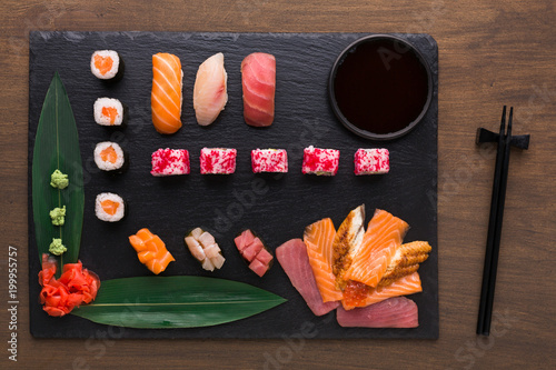 Set of assorted sushi, maki and rolls on rustic wooden background