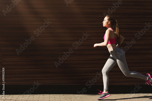 Young woman jogging in city copy space