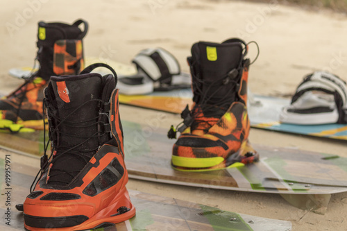 Kitesurf boards ready for action.  Freestyle and regular kitesurf boards are ready on the beack. Boots are used for freestyle jumping, whereas regulars or sandals are used by begginers