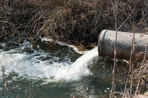Concrete pipe transporting the poluted river in to a small pound.