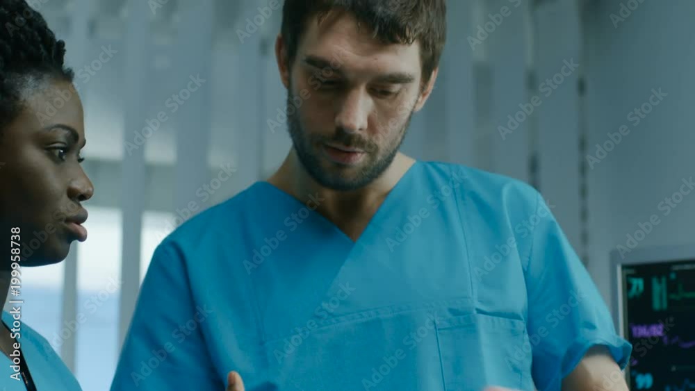 In the Hospital Male and Female Nurses Use Tablet Computer while Talking. Professional Medical Staff Working in the Hospital Ward. Shot on RED EPIC-W 8K Helium Cinema Camera. In the Hospital Male and Female Nurses Use Tablet Computer while Talking. Professional Medical Staff Working in the Hospital Ward. Shot on RED EPIC-W 8K Helium Cinema Camera.
