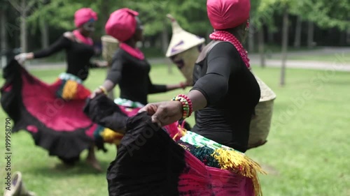 Three african women dancing folk dance in traditio.costumes with coats of skirts photo