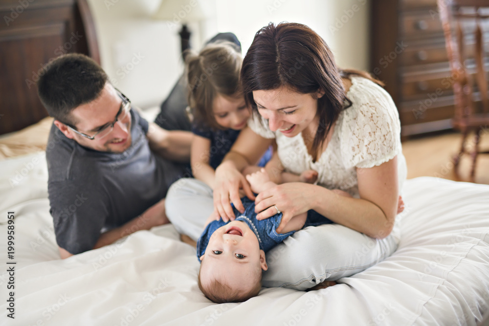 happy family mother, father and two children at home in bed happy family mother, father and two children at home in bed