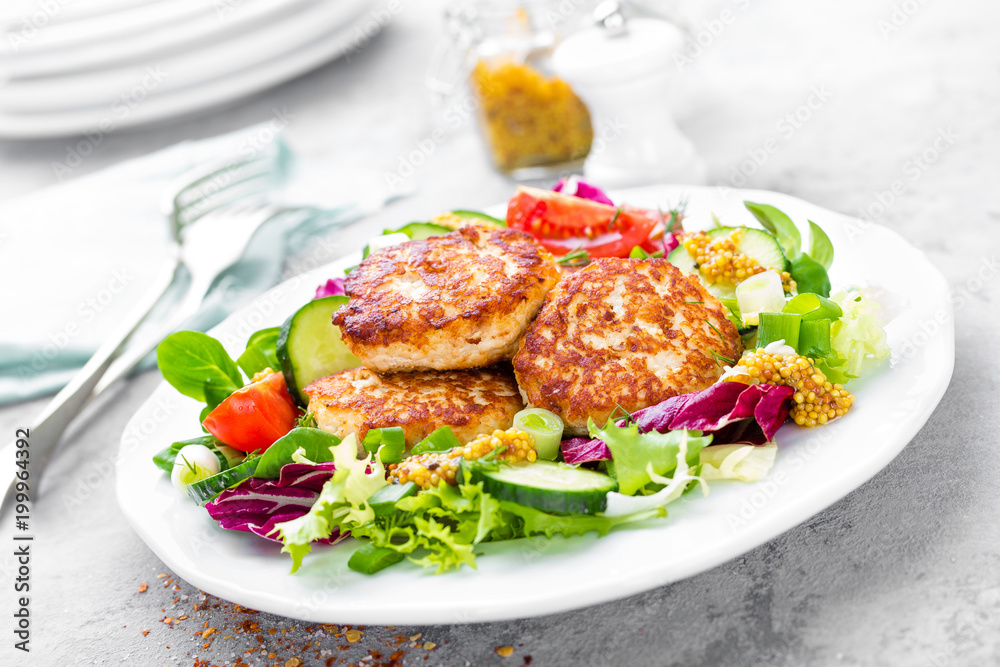 Cutlets and fresh vegetable salad on white plate. Fried meatballs with vegetable salad Cutlets and fresh vegetable salad on white plate. Fried meatballs with vegetable salad