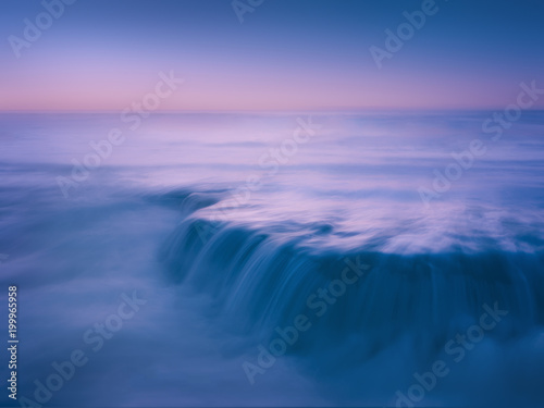 dreamy and beautiful seascape with rock and long exposure on beach