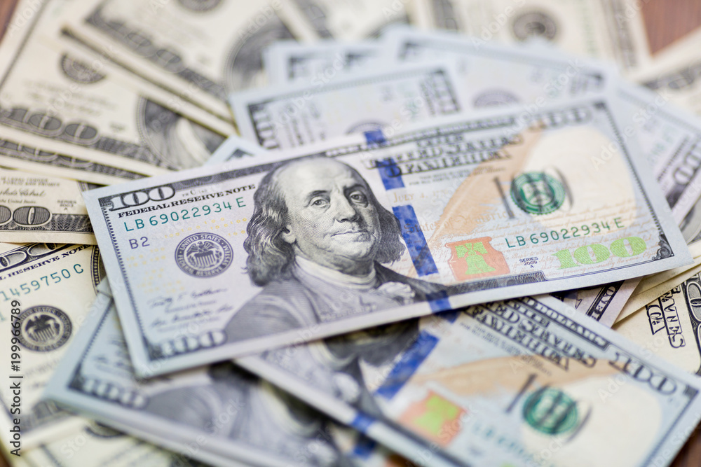 A pack of American hundred-dollar bills is lying on the table with a fan so that the focus is on looking into the frame of Benjamin Franklin. A pack of American hundred-dollar bills is lying on the table with a fan so that the focus is on looking into the frame of Benjamin Franklin.