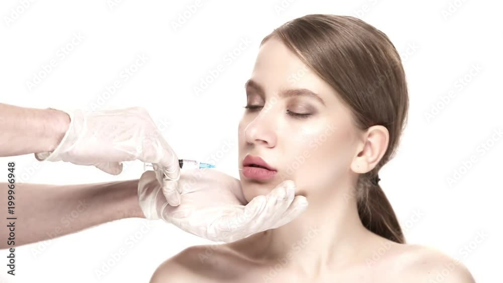 Professional botox injection into the lower lip of the beautiful woman Professional botox injection into the lower lip of the beautiful woman
