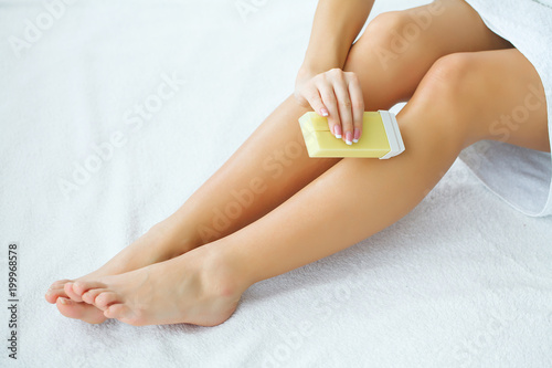 Depilation on the female legs with waxing