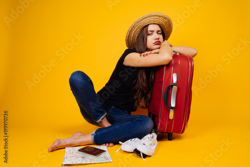 Billede på lærred a sad disgruntled girl in a hat is waiting for her flight for a long time, goes