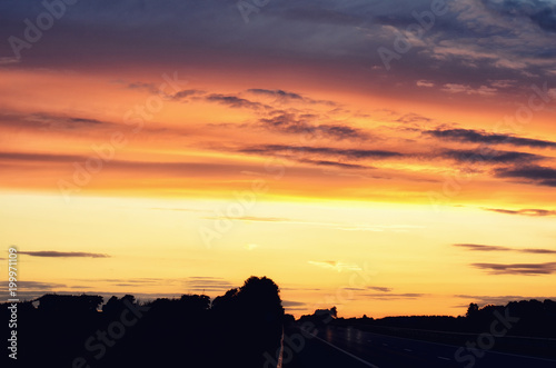 Empty asphalt road and sun rising on skyline. Colorful sunset over road. Minimalist style design. Nature background, landscape with copy space. Banner