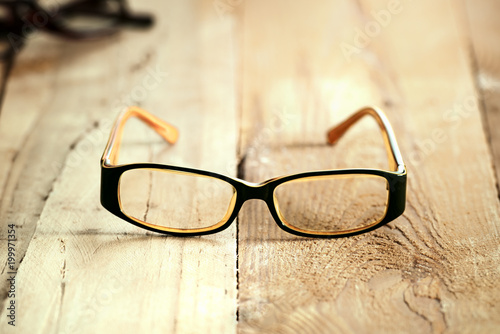 Black orange glasses on wooden board