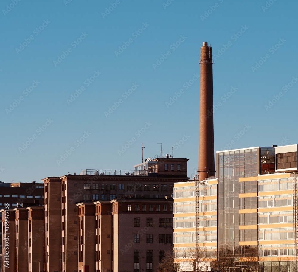 A chimney and buildings over the sunset A chimney and buildings over the sunset