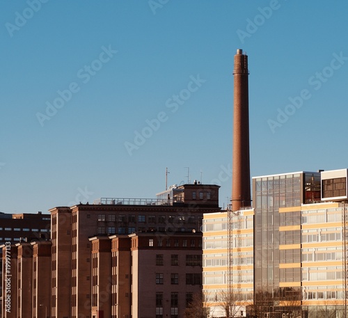 A chimney and buildings over the sunset