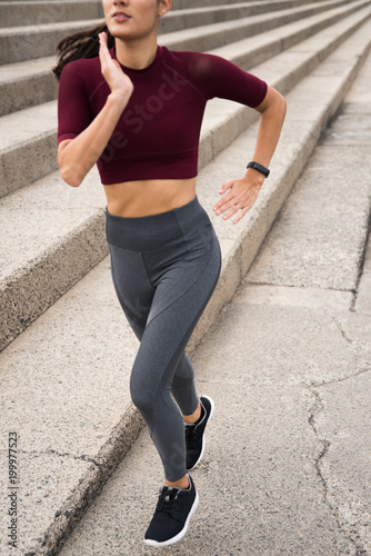 Sporty brunette running next to stairs