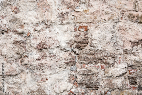 Old wall made of big stones and broken bricks. Vintage rough blocks surface background