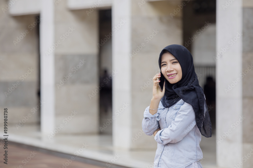 Muslim woman speaking on the smartphone Muslim woman speaking on the smartphone