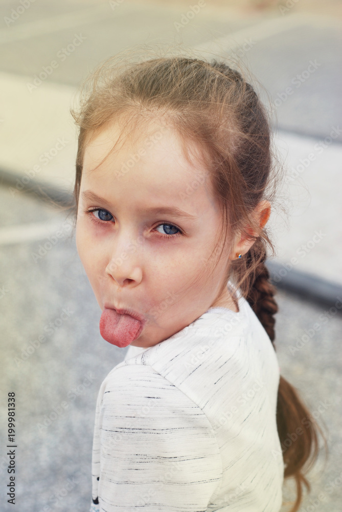 Portret Llittle Blod Girl Showing the Tongue Naughty Face Expression. long Hair Blue Eyes Portret Llittle Blod Girl Showing the Tongue Naughty Face Expression. long Hair Blue Eyes