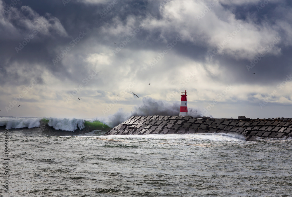 Stormy oceans with big waves crashing into a lighthouse