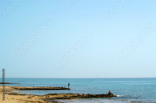 Two men fishing in the sea with rods © Vadim