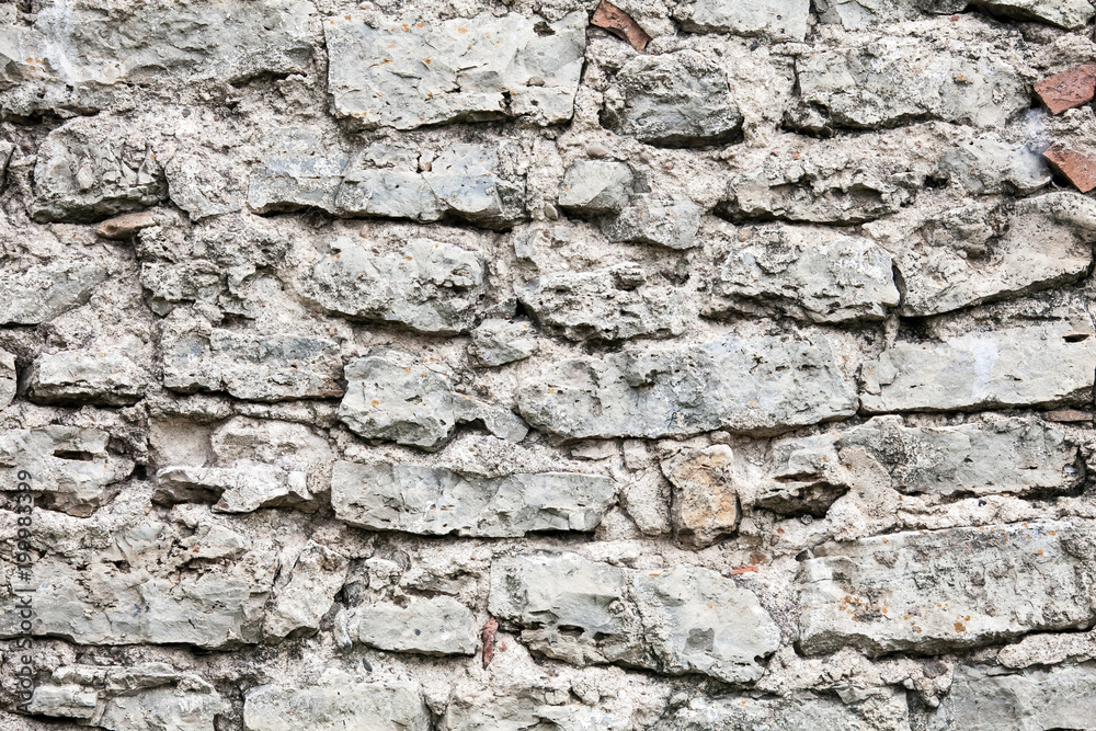 Old wall made of big stones and broken bricks. Vintage rough blocks surface background