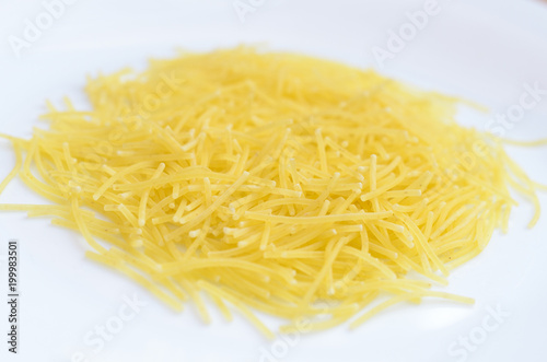 Thin yellow mackerons on a white plate.
