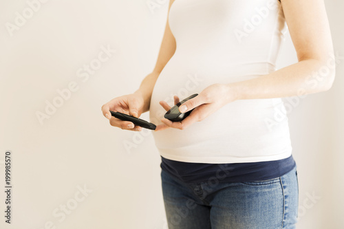 Pregnant woman checking blood sugar level. Gestational diabetes. Pregnancy health photo