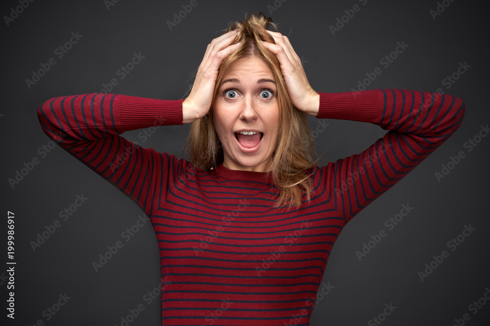 large Studio portrait on an isolated black background of a slender blonde girl with eyes wide open and mouth large Studio portrait on an isolated black background of a slender blonde girl with eyes wide open and mouth