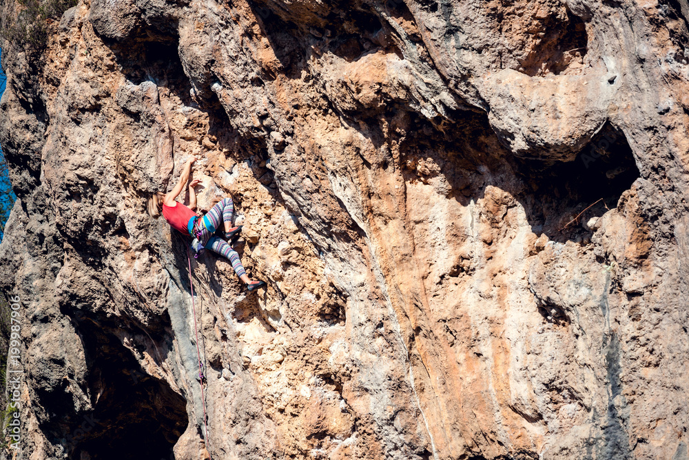 A woman climbs the rock. A woman climbs the rock.
