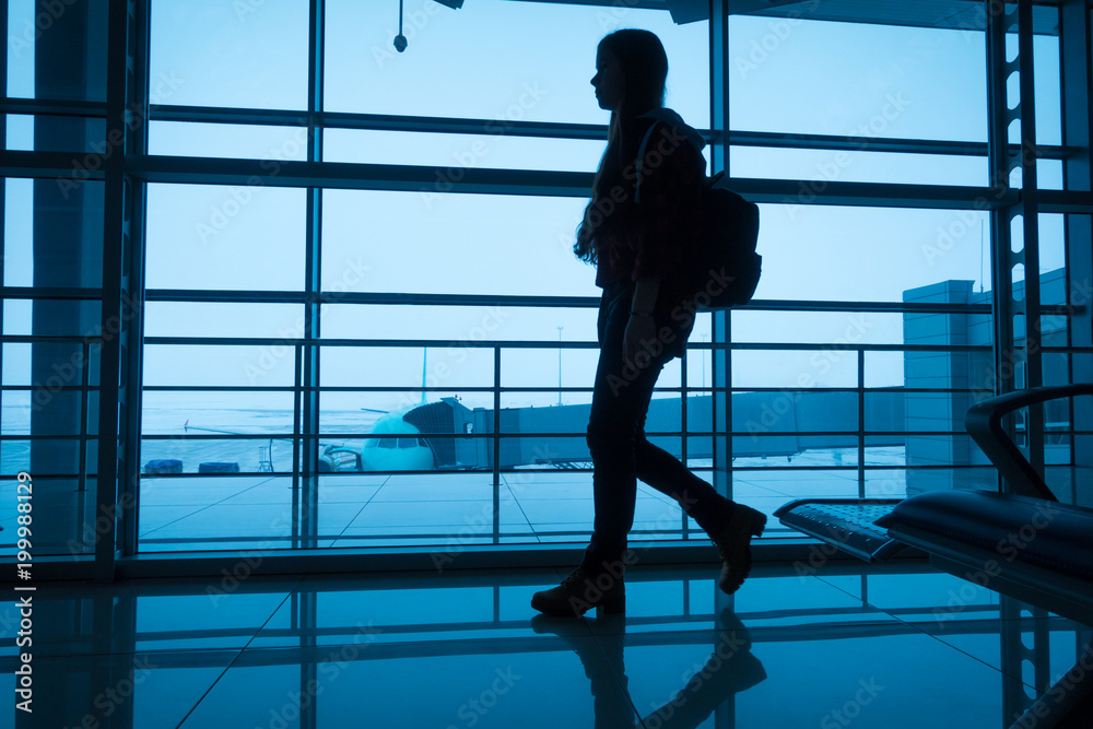 Silhouette of girl walking on airport terminal Silhouette of girl walking on airport terminal