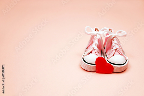 Baby sneakers on pink background