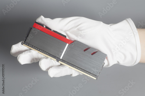 Hand in white glove holding High performance DDR4 computer memor photo