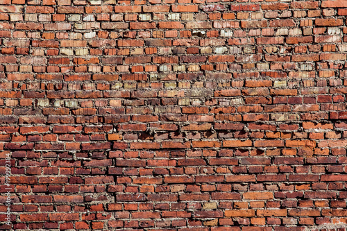 Grunge brick wall background, red cracked stones texture. Construction blocks in a line