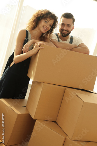 фотографія Happy couple honeymooners standing near boxes