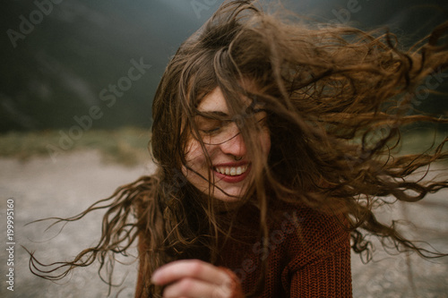 Woman Smiling With Wind Blowing Her Long Hair Around Her Face