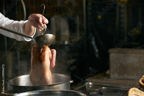 Chef is cooking beijing duck in the kitchen of restaurant. Peking Duck is a famous duck dish from Beijing photo