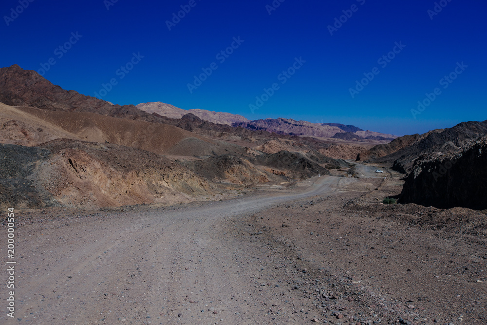 Way in the desert  in the Israil in sunny day with red mountains and blue sky