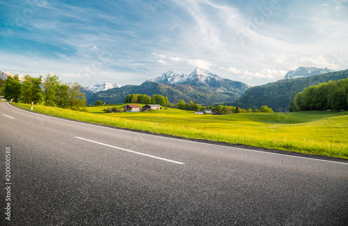 Empty asphalt country road with alpine mountain scenery in summer