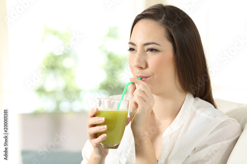 Girl drinking vegetable juice sipping a straw