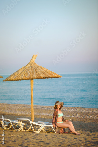 Girl sitting on a beach  under an beach umbrella