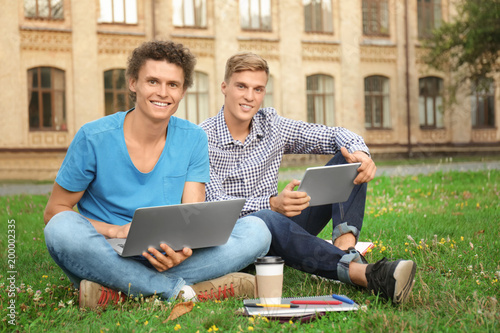 Young male students sitting...
