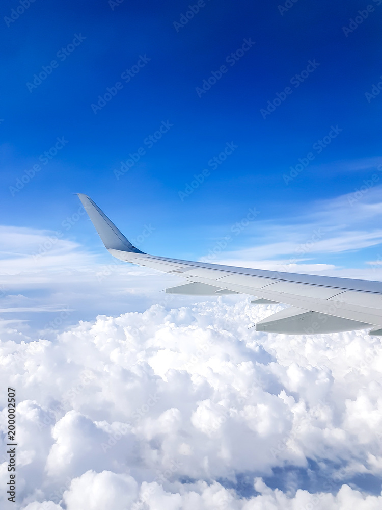 Picture of airplane wing, cloudy sky from porthole Picture of airplane wing, cloudy sky from porthole