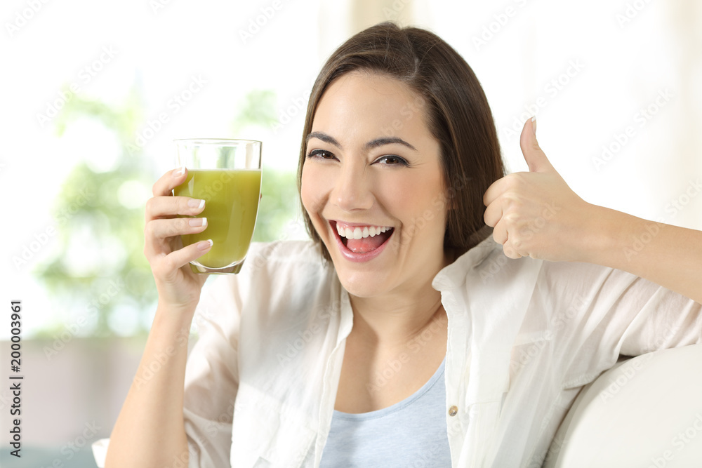 Woman holding a vegetable juice with thumbs up Woman holding a vegetable juice with thumbs up