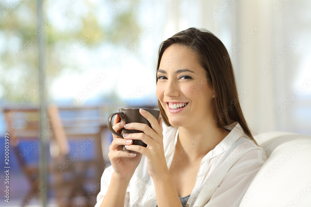 Woman looking at camera holding a coffee mug Woman looking at camera holding a coffee mug