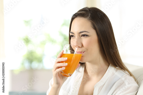 Woman drinking orange juice in a glass