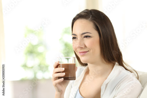 Woman holding a cocoa shake looking away