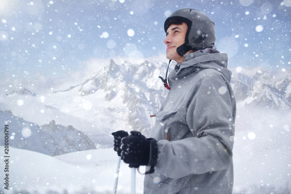 Cheerful skier looking afar before starting to skiing. Happy man enjoying holiday in winter season. Smiling mountaineer skier Cheerful skier looking afar before starting to skiing. Happy man enjoying holiday in winter season. Smiling mountaineer skier