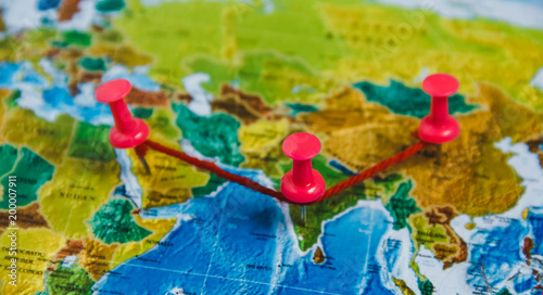 Travel Destination Points on World Map Indicated with Colorful Thumbtacks, Red Ribbon and Shallow Depth of Field.