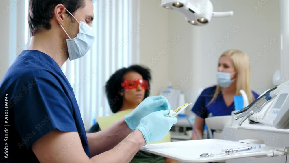 Dentist and his assitant working in private practice. Dentist and his assitant working in private practice.